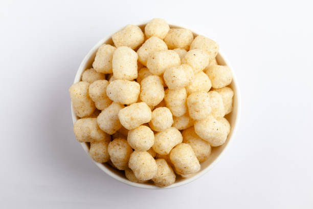 Close up of Cheese Potato Puff Snacks ball and buds, Popular Ready to eat crunchy and puffed snacks buds, cheesy salty pale-yellow color over white background